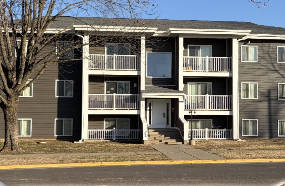 Sycamore Village, Pittsburg, KS — after: the renovated building with dark siding and new balconies